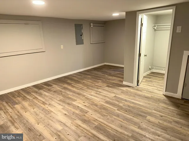 a view of an empty room with closet and a window