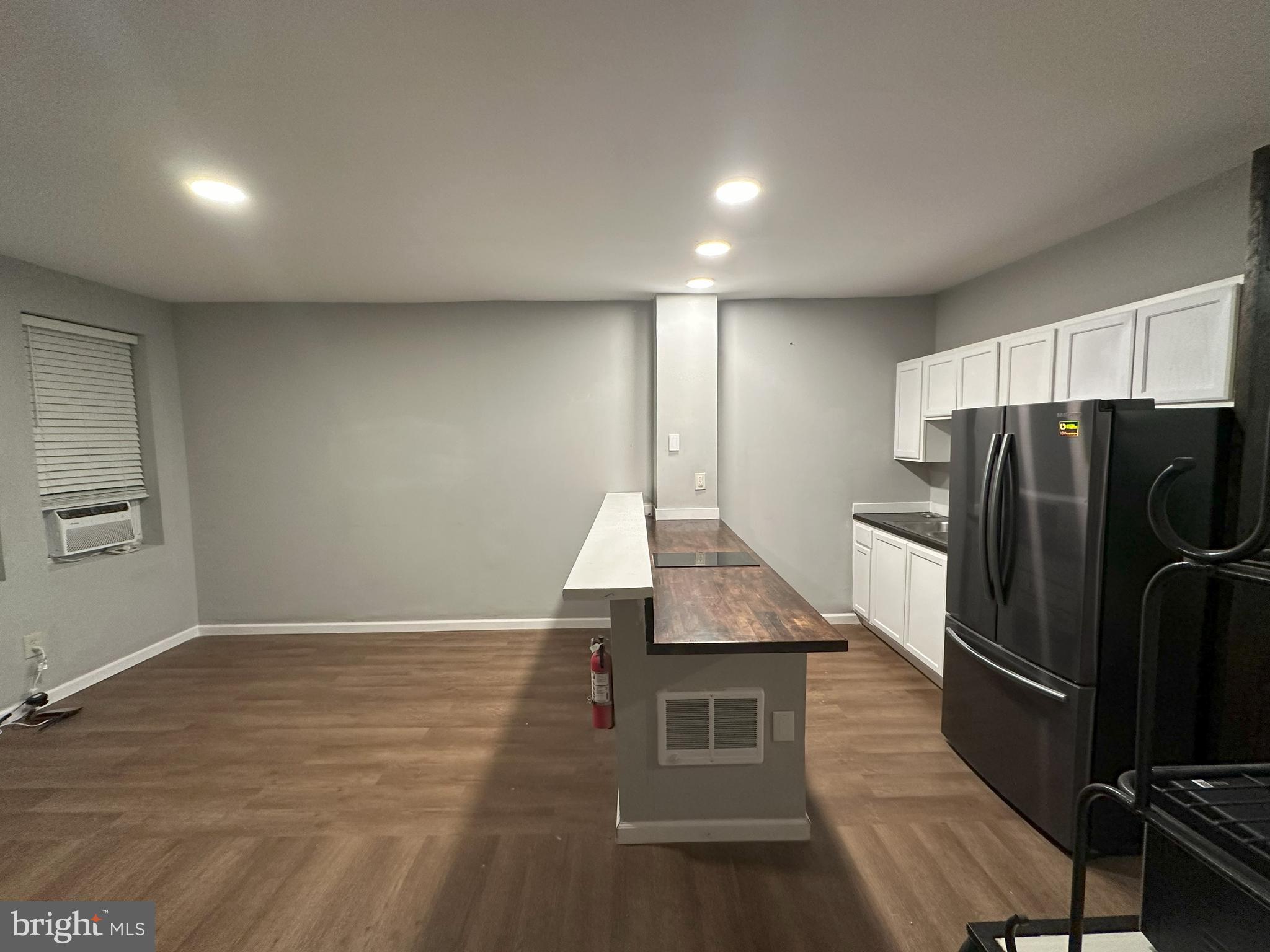 1510 Sycamore Street Curtis Bay, MD 21226 - Photo 7 of 23 an empty room with wooden floor and a kitchen view