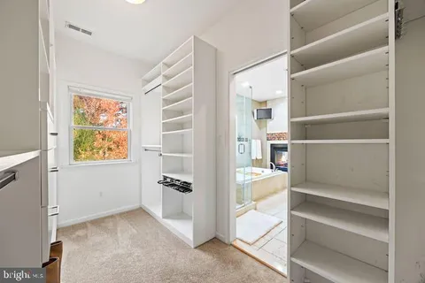 a view of walk in closet with empty racks