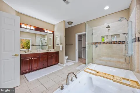 a bathroom with a granite countertop tub sink and mirror
