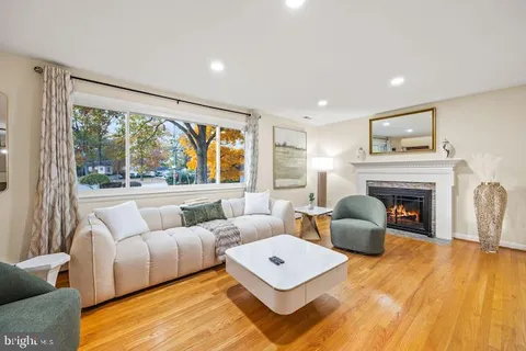 a living room with furniture a large window and a fireplace