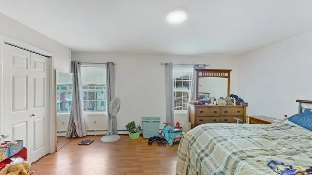 a bedroom with a bed and large windows