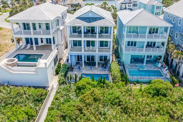 a view of multiple house with palm trees
