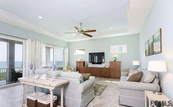 a living room with furniture a large window and a flat screen tv