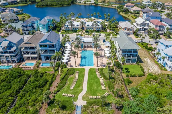 an aerial view of a house with a swimming pool a yard and a fountain