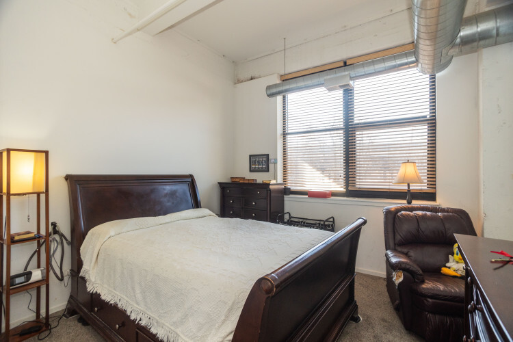 2323 West Pershing Road, Unit 140 Chicago, IL 60609 - Photo 11 of 18 a bedroom with a bed and a couch