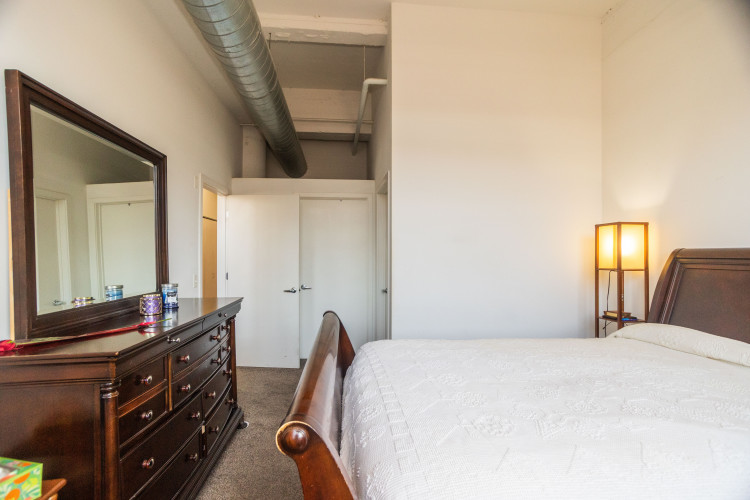 2323 West Pershing Road, Unit 140 Chicago, IL 60609 - Photo 12 of 18 a bedroom with a bed and a mirror on dresser