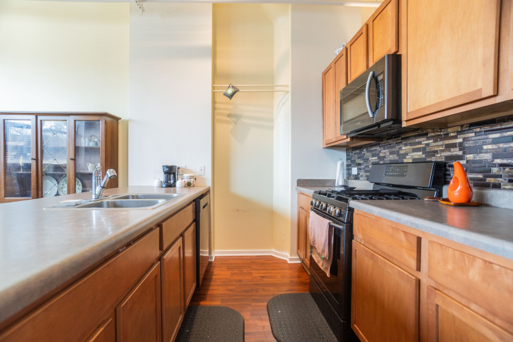 2323 West Pershing Road, Unit 140 Chicago, IL 60609 - Photo 10 of 18 a kitchen with stainless steel appliances granite countertop a sink stove and refrigerator