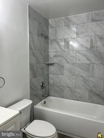 a white toilet and tub sitting next to a bathroom sink