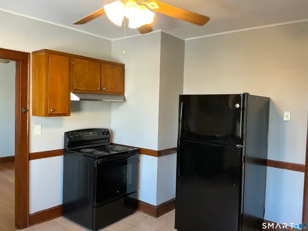 an empty room with wooden floor mirror and windows