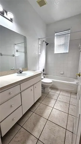 a spacious bathroom with a double vanity sink toilet and a mirror