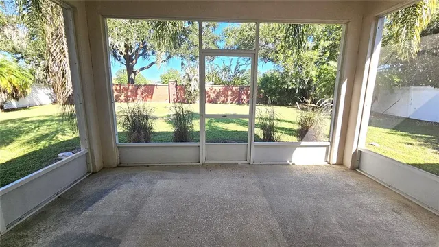 a view of an empty room with wooden floor and a floor to ceiling window