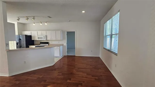 a kitchen with kitchen island white cabinets and stainless steel appliances