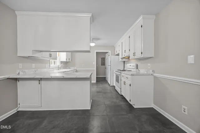 a kitchen with granite countertop white cabinets and white appliances
