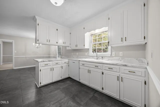 a kitchen with granite countertop white cabinets and a sink