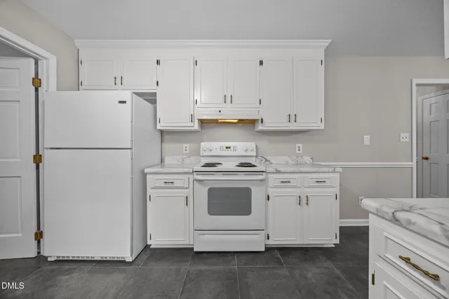a kitchen with cabinets appliances a sink and a refrigerator