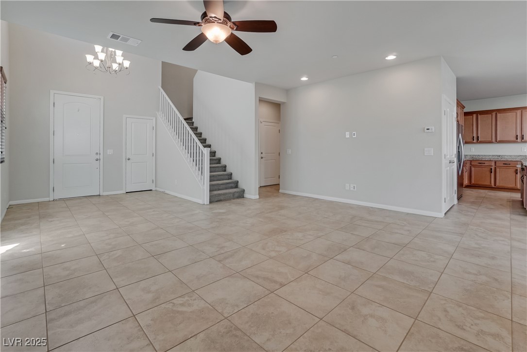 1145 Strada Pecei Henderson, NV 89011 - Photo 11 of 61 Unfurnished living room with stairs, ceiling fan, recessed lighting, a chandelier, and light tile patterned flooring