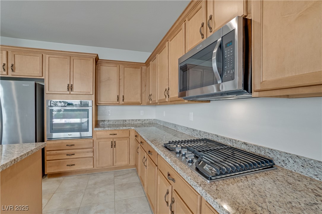 1145 Strada Pecei Henderson, NV 89011 - Photo 14 of 61 Kitchen with light brown cabinetry, appliances with stainless steel finishes, and light tile patterned floors