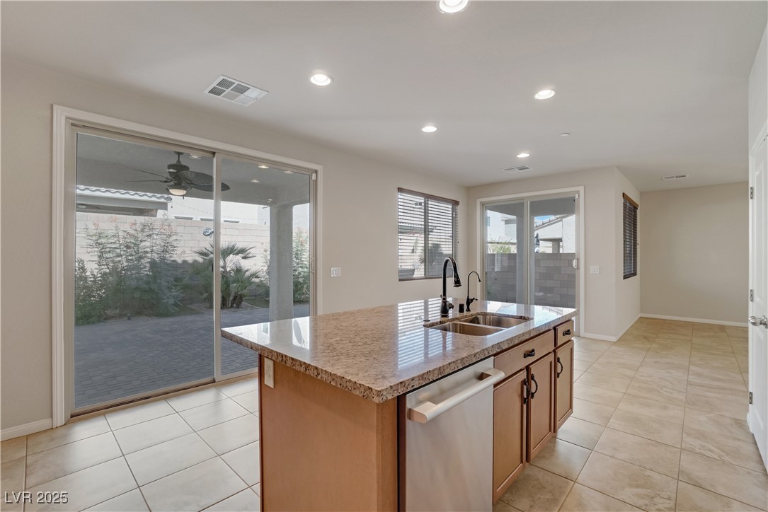 1145 Strada Pecei Henderson, NV 89011 - Photo 15 of 61 Kitchen featuring stainless steel dishwasher, light tile patterned floors, a center island with sink, a ceiling fan, and recessed lighting