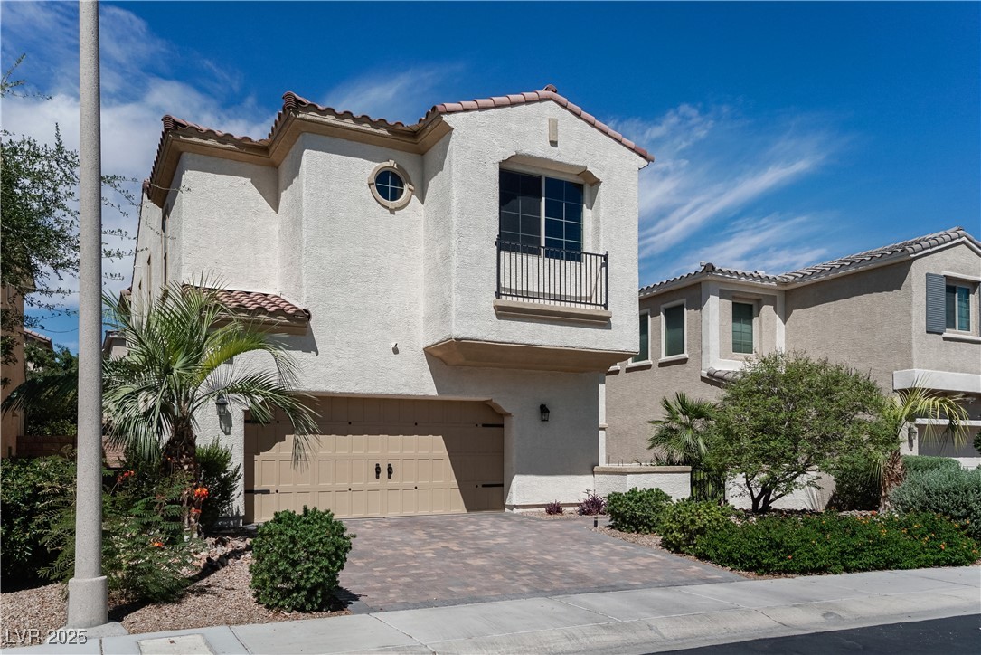 1145 Strada Pecei Henderson, NV 89011 - Photo 2 of 61 Mediterranean / spanish house with a garage, a balcony, stucco siding, and a tiled roof