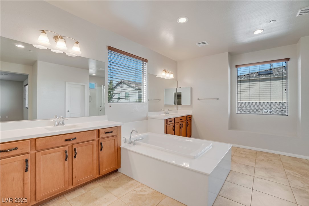 1145 Strada Pecei Henderson, NV 89011 - Photo 25 of 61 Bathroom with a bath, tile patterned floors, two vanities, and recessed lighting