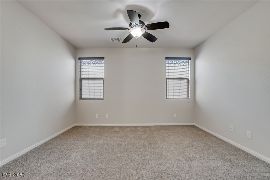 1145 Strada Pecei Henderson, NV 89011 - Photo 30 of 61 Empty room featuring carpet flooring, healthy amount of natural light, and a ceiling fan