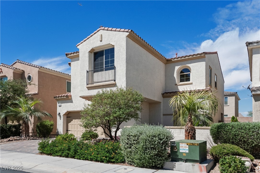 1145 Strada Pecei Henderson, NV 89011 - Photo 3 of 61 Mediterranean / spanish-style home with a tiled roof, a garage, a balcony, and stucco siding