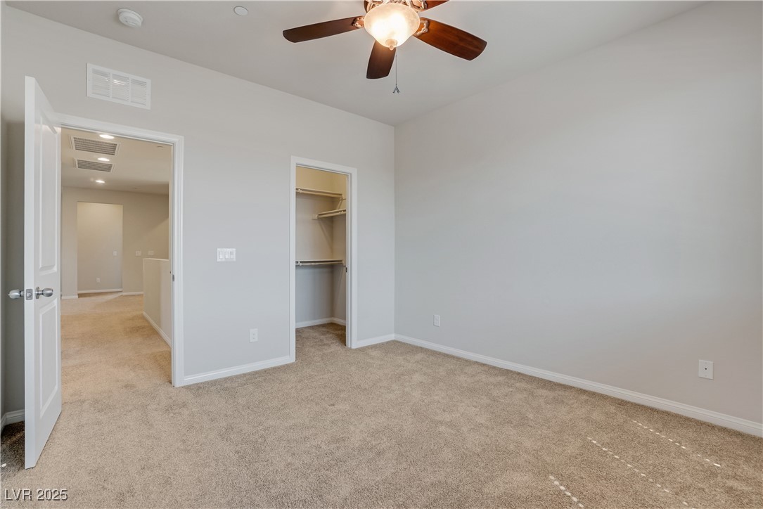 1145 Strada Pecei Henderson, NV 89011 - Photo 32 of 61 Unfurnished bedroom featuring light carpet, a spacious closet, and a ceiling fan
