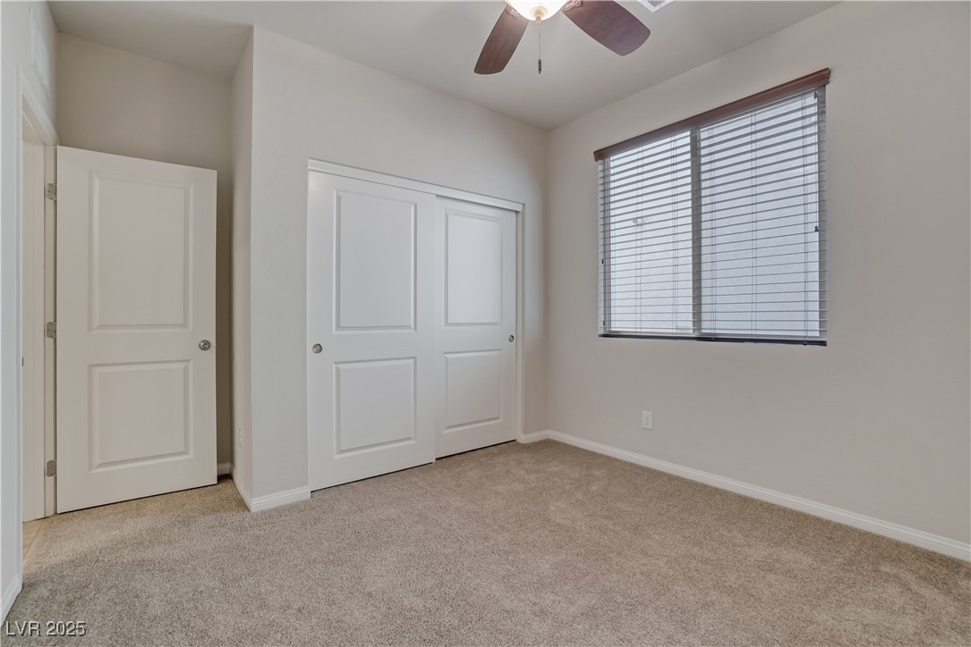 1145 Strada Pecei Henderson, NV 89011 - Photo 36 of 61 Unfurnished bedroom with light colored carpet, a closet, and a ceiling fan