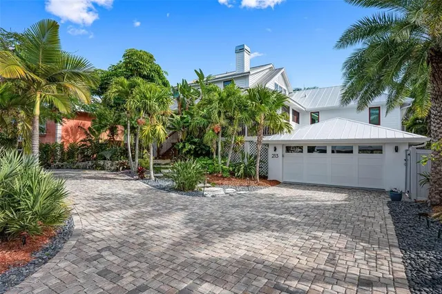 a view of a house with a yard and potted plants