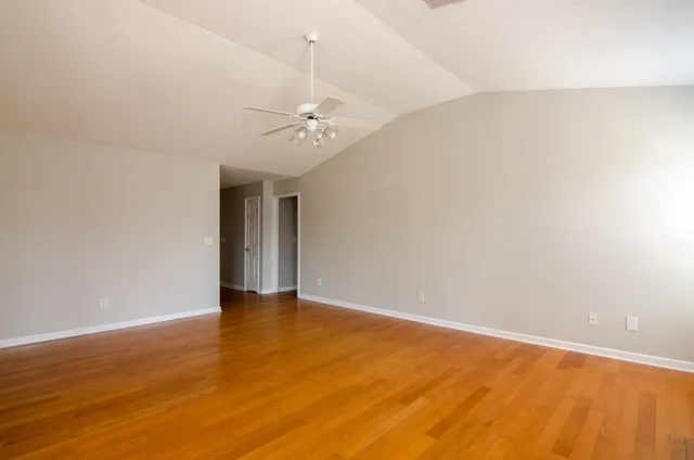 a view of an empty room with wooden floor