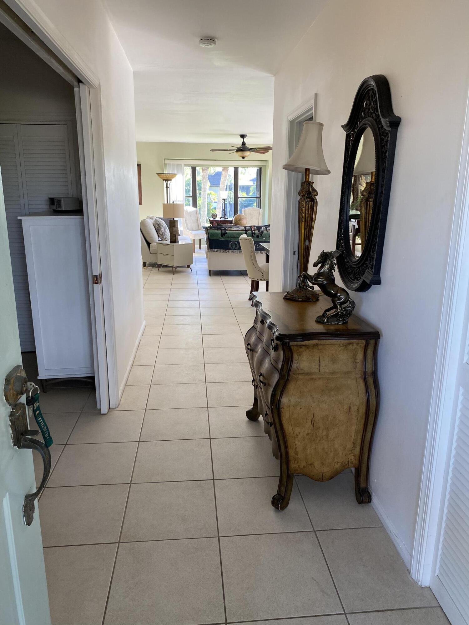 13321 Polo Club Road, Unit C 202 Wellington, FL 33414 - Photo 3 of 20 a living room with furniture and a mirror