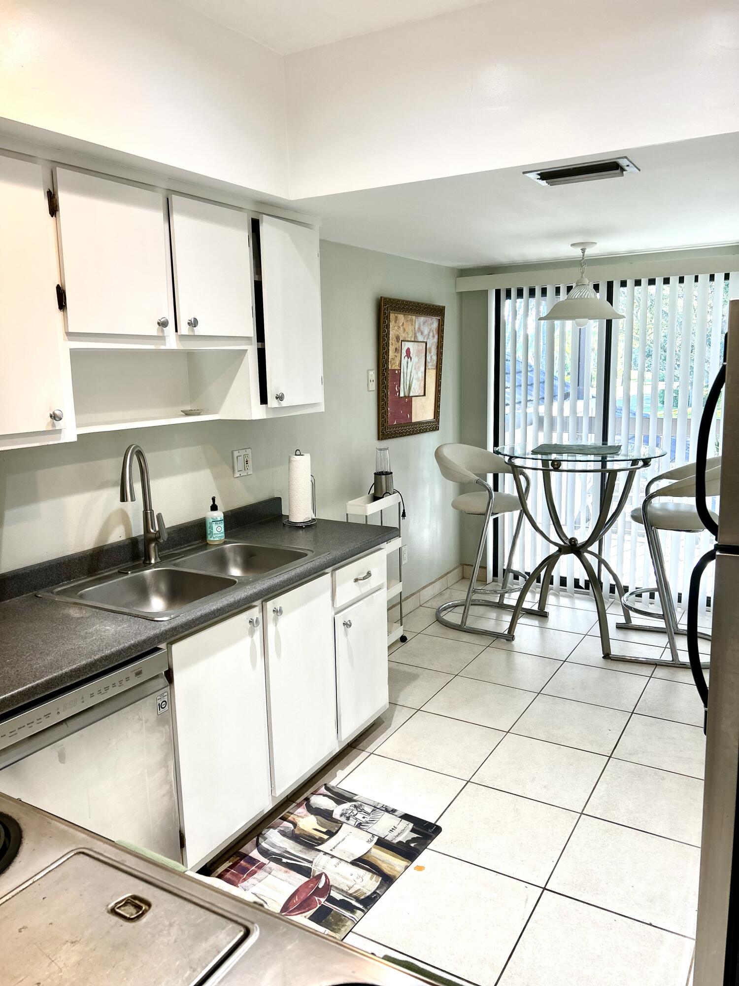 13321 Polo Club Road, Unit C 202 Wellington, FL 33414 - Photo 6 of 20 a kitchen with a sink and a stove top oven