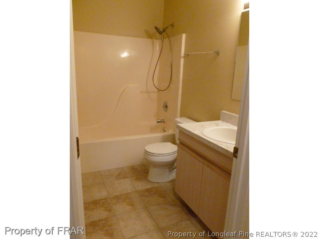 1813 Sardonyx Road Fayetteville, NC 28303 - Photo 18 of 25 a bathroom with a granite countertop toilet a sink and a mirror