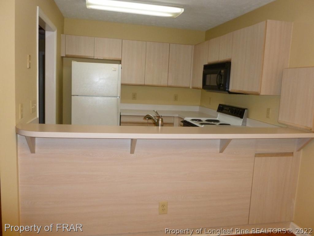 1813 Sardonyx Road Fayetteville, NC 28303 - Photo 9 of 25 a kitchen with a sink a refrigerator and cabinets