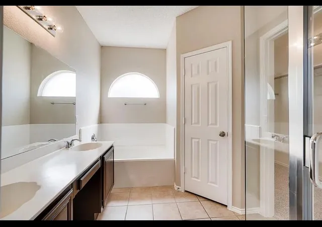 a bathroom with a tub sink and mirror