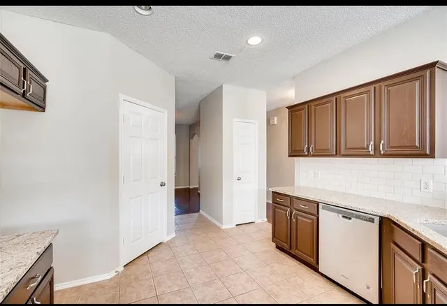 a kitchen with granite countertop a refrigerator and a sink