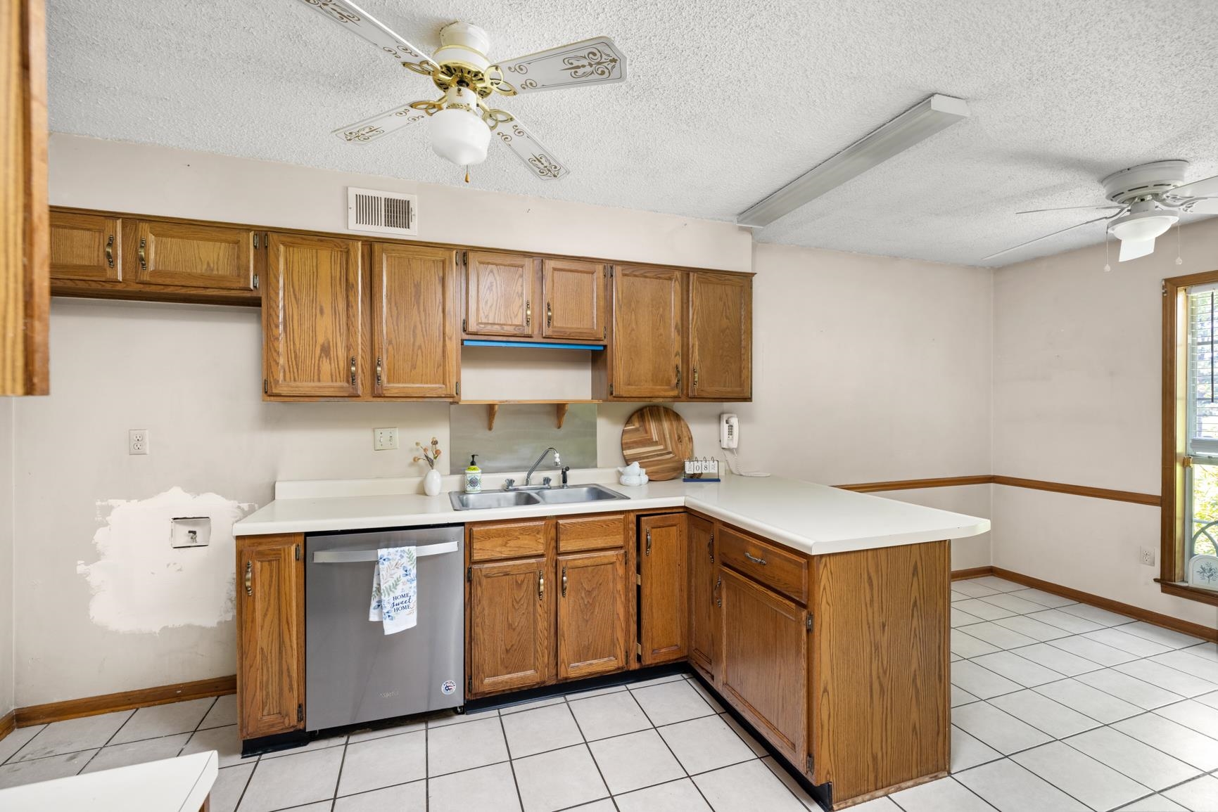5015 Eagles Nest Lane Bartlett, TN 38002 - Photo 14 of 39 Kitchen with stainless steel dishwasher, ceiling fan, a peninsula, brown cabinetry, and a textured ceiling