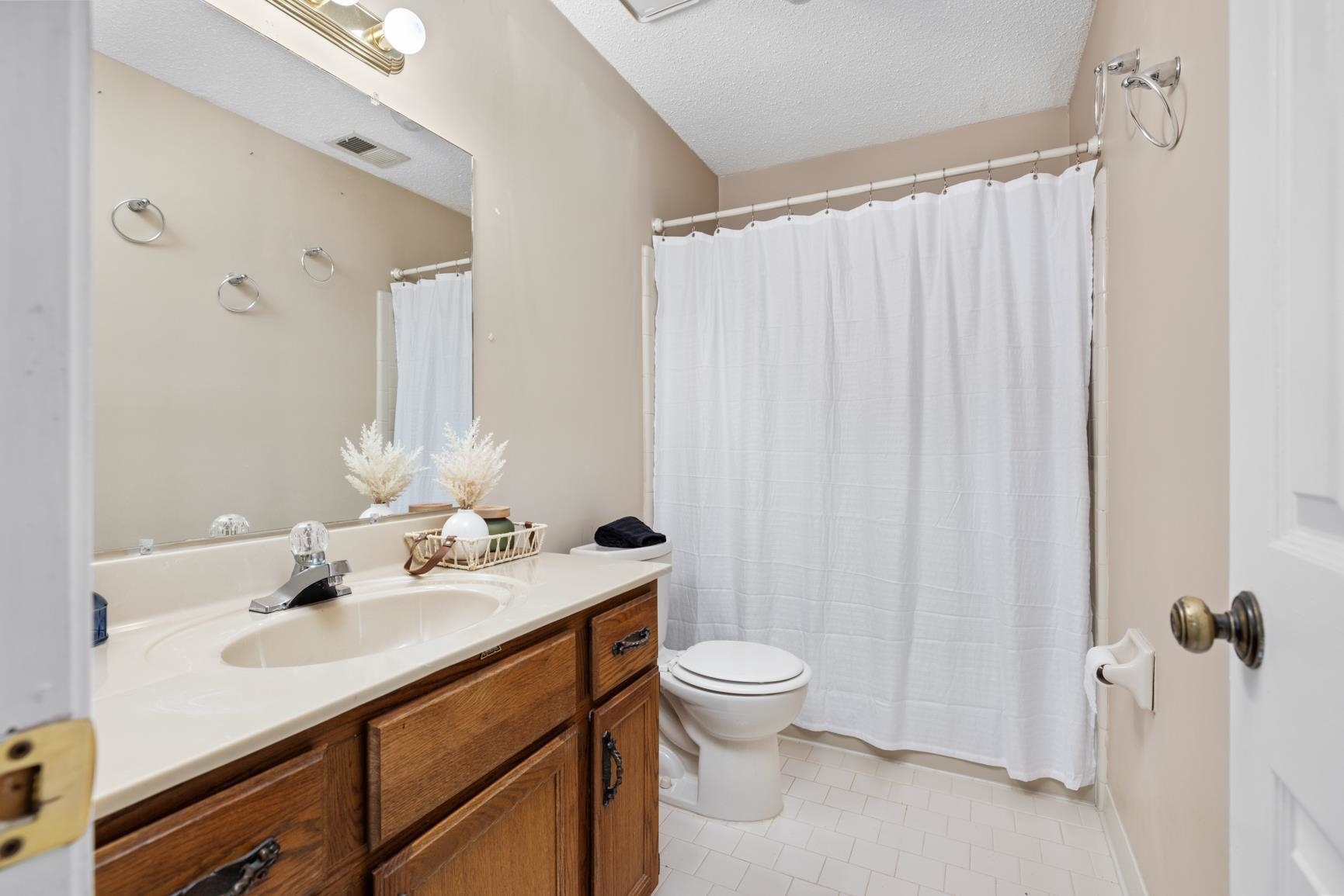 5015 Eagles Nest Lane Bartlett, TN 38002 - Photo 21 of 39 Full bathroom with vanity, tile patterned flooring, a textured ceiling, and a shower with shower curtain