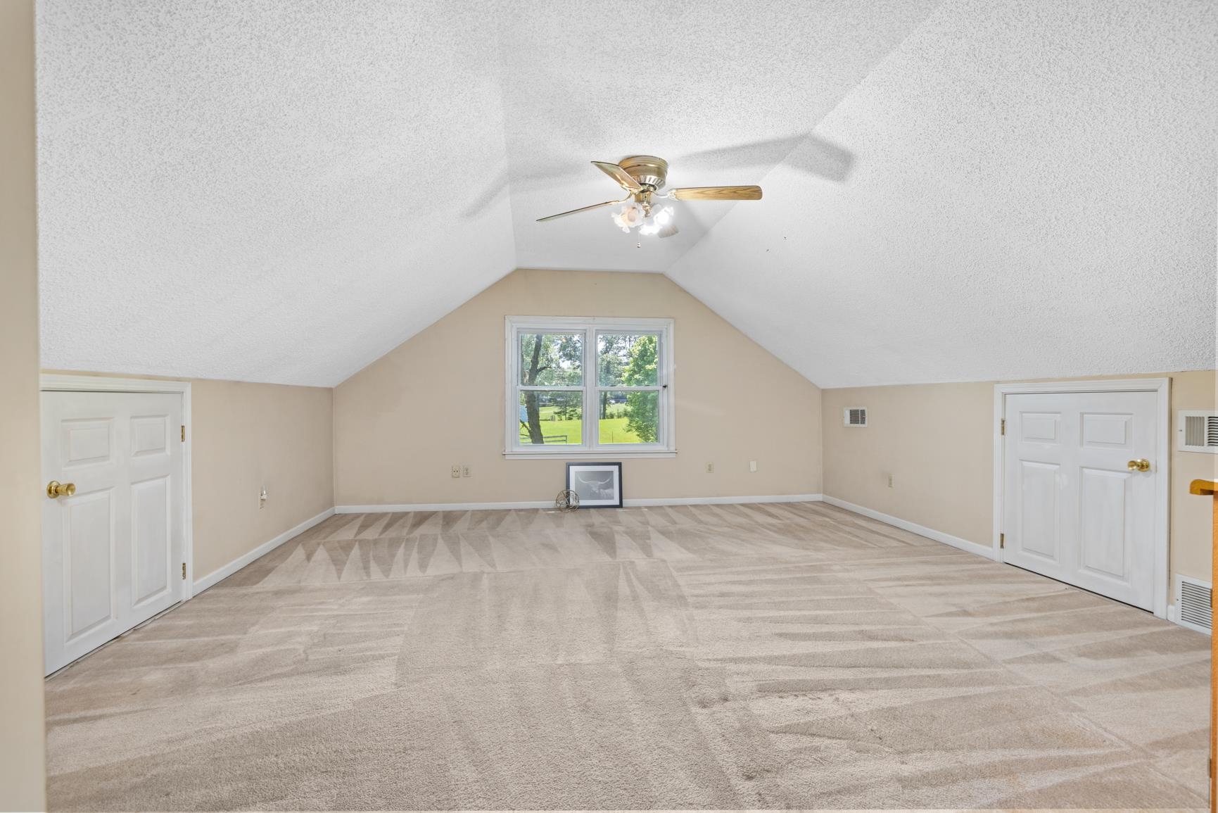 5015 Eagles Nest Lane Bartlett, TN 38002 - Photo 28 of 39 Additional living space with a ceiling fan, a textured ceiling, light colored carpet, and vaulted ceiling