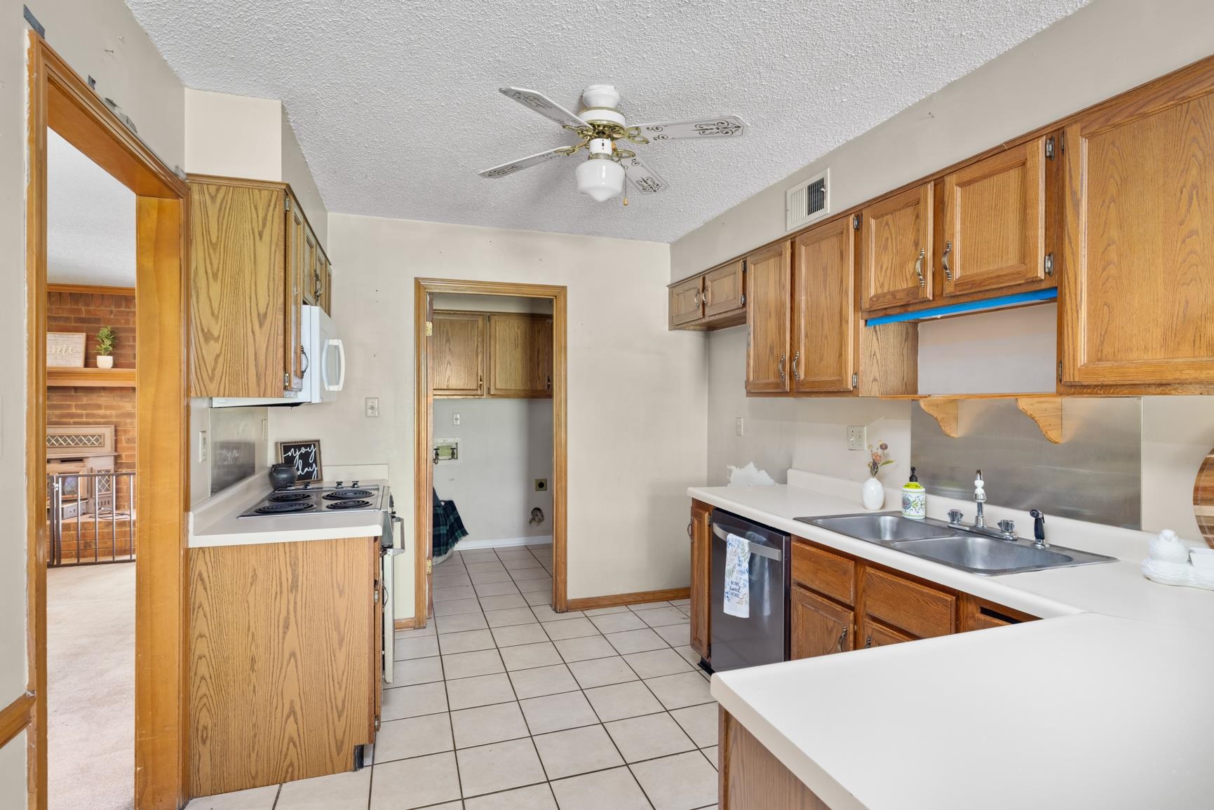 5015 Eagles Nest Lane Bartlett, TN 38002 - Photo 10 of 39 Kitchen with stainless steel appliances, light tile patterned flooring, a ceiling fan, brown cabinetry, and a textured ceiling