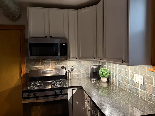 a kitchen with stainless steel appliances a stove a sink and a microwave