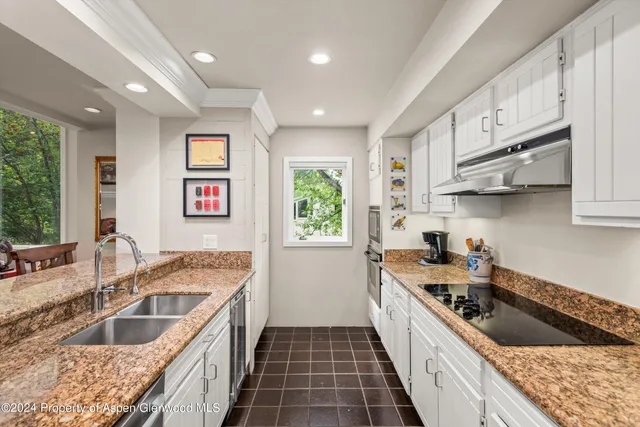 a kitchen with stainless steel appliances granite countertop a sink stove and cabinets