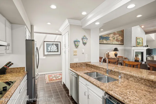 a kitchen with granite countertop a sink and a stove top oven