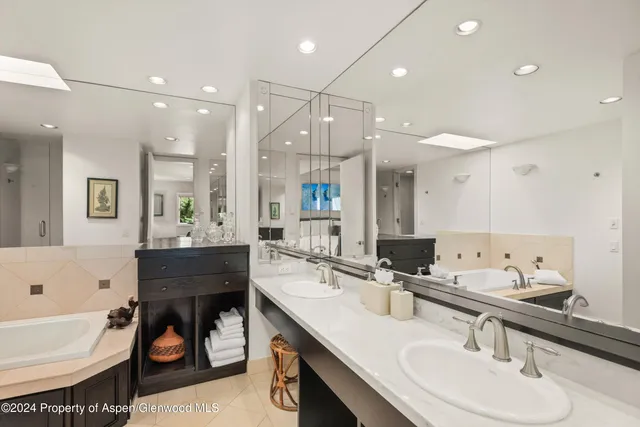 a bathroom with a sink double vanity and tub