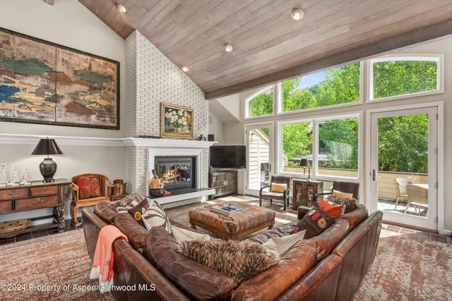 a living room with furniture large window and a fireplace