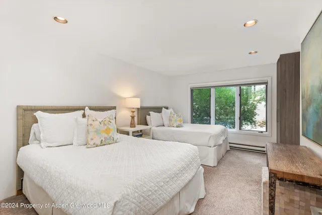 a bed room with two beds and a large window