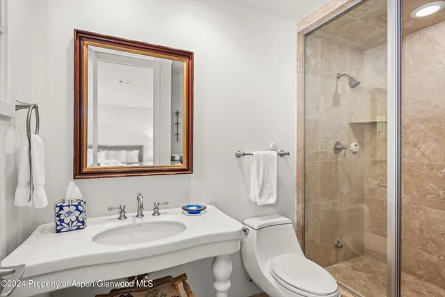 a bathroom with a toilet a sink and shower