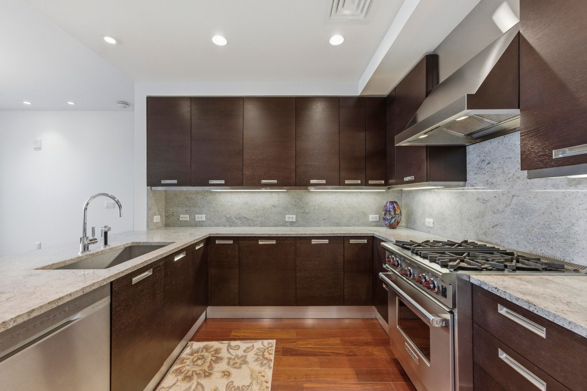 200 Congress Avenue, Unit 14A Austin, TX 78701 - Photo 14 of 40 a kitchen with stainless steel appliances granite countertop a sink stove and cabinets