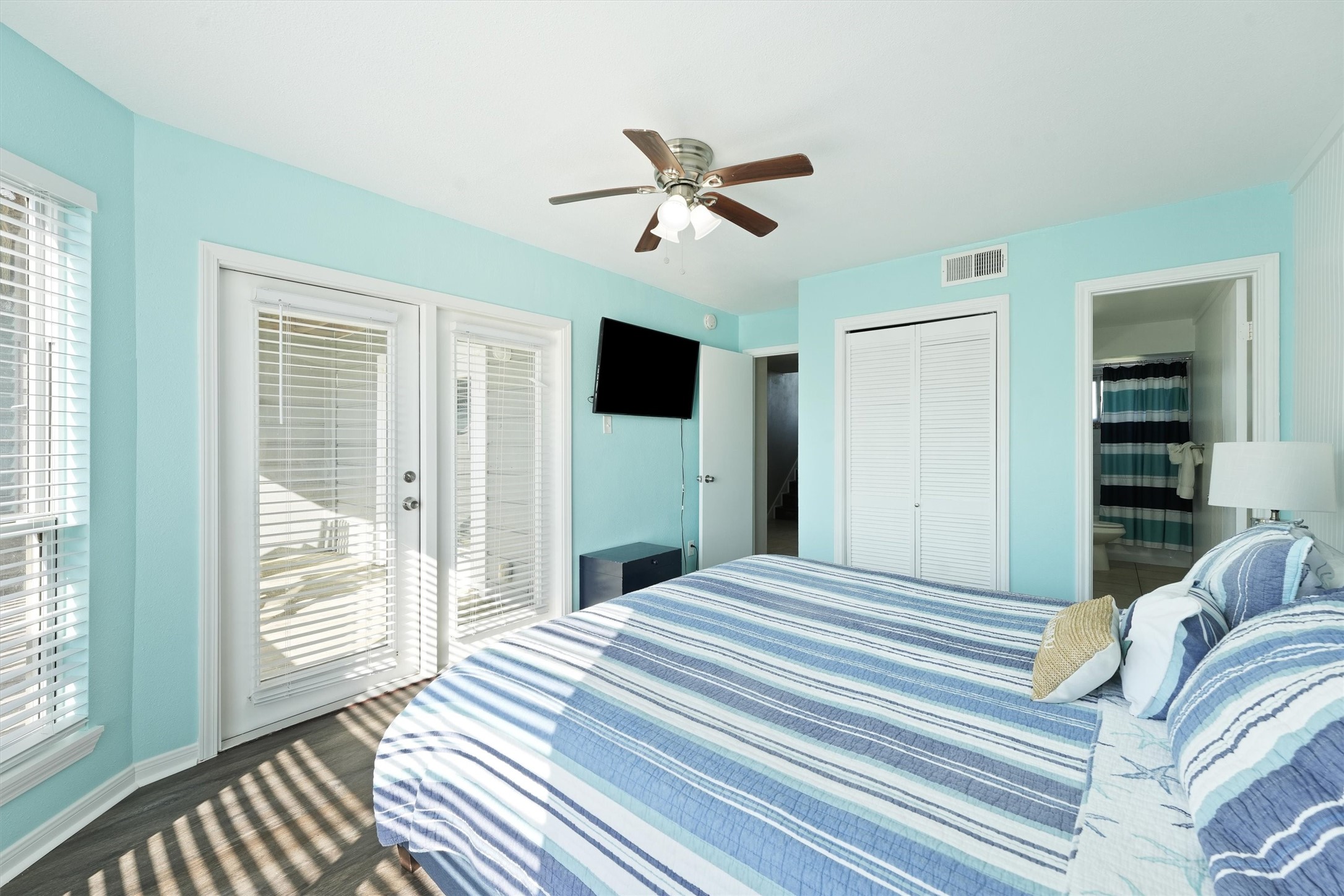 17607 Termini-San Luis Pass Road Galveston, TX 77554 - Photo 21 of 42 French doors in the primary bedroom lead to a covered balcony, adding a relaxing touch to the room. The ensuite bathroom is conveniently accessible, offering a serene retreat with modern fixtures.